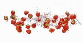 Splash mit Erdbeeren und Wasser — Stockfoto