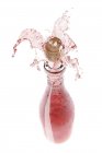 Vino rosa spruzzando dalla bottiglia — Foto stock