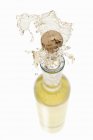 Белое вино распыляется из бутылки — стоковое фото