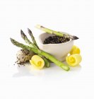 Asparagus, butter curls and peppercorns in a mortar — Stock Photo