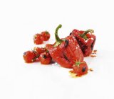 Pimentos e tomates vermelhos assados sobre fundo branco — Fotografia de Stock