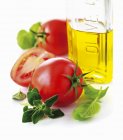 Tomates y botella de aceite de oliva - foto de stock