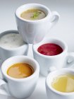 Крупный план различных супов в белых чашках — стоковое фото