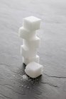 Closeup view of stacked sugar cubes on stone surface — Stock Photo