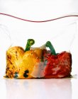 Due peperoni alla griglia in un sacchetto congelatore su superficie bianca — Foto stock