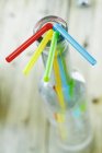 Vista close-up de palhas de bebida coloridas em uma garrafa de vidro vazia — Fotografia de Stock