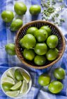 Limes whole and in wedges — Stock Photo