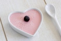 Vista close-up de flan framboesa em um prato em forma de coração — Fotografia de Stock