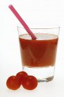 Tomato juice in glass with straw — Stock Photo