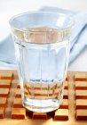 Glass of water on wooden tray — Stock Photo
