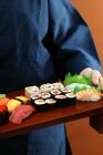 Pessoa que serve conjunto de sushi — Fotografia de Stock