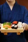 Mujer sirviendo sushi set - foto de stock
