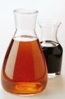 Closeup view of sesame oil and balsamic vinegar in carafes — Stock Photo