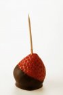 Closeup view of chocolate-coated strawberry on toothpick — Stock Photo