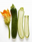 Ganze und halbe Zucchini mit Blüten — Stockfoto