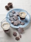 Elevated view of chocolate star-shaped cookies with drinks — Stock Photo