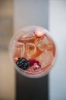 Closeup top view of drink with berries and ice cubes — Stock Photo