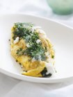 Vista close-up de omelete com cebolinha e endro em prato branco — Fotografia de Stock