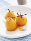Closeup view of preserved pears with chocolate on white plate — Stock Photo