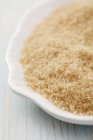 Closeup view of brown cane sugar in white dish — Stock Photo
