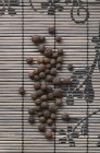 Bacche di pimento su tappetino di bambù — Foto stock