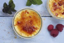 Top view of creme brulee with raspberries and mint leaves — Stock Photo