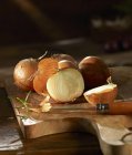 Onions on a wooden chopping board — Stock Photo