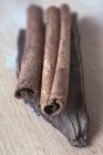 Bâtonnets de cannelle sur un morceau de cannelle cassia — Photo de stock