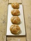 Quatre petits pains frais — Photo de stock