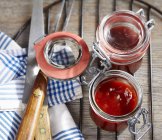 Homemade barbecue sauce in preserving jars over wooden surface — Stock Photo