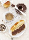 Blick von oben auf geröstete Brioche-Brötchen mit Schokoladenaufstrich serviert mit Kaffee — Stockfoto