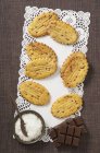 Vista superior de Sable galletas francesas con barras de chocolate y hojuelas de coco en tapete - foto de stock
