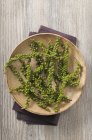 Vue de dessus des vignes de poivre vert sur une assiette en bois — Photo de stock