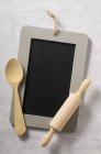 Top view of a chalkboard, a wooden spoon and a rolling pin — Stock Photo