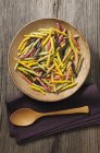 Colourful pasta in wooden bowl — Stock Photo