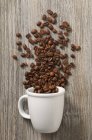 Grains de café et tasse blanche — Photo de stock