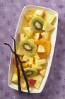 Primer plano vista superior de ensalada de frutas exóticas con vainas de vainilla - foto de stock