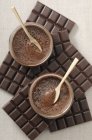 Vista dall'alto della crema di cioccolato in ciotole di vetro su barrette di cioccolato — Foto stock