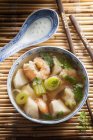 Креветочный суп с луком-порей над соломенным ковриком с палочками для еды — стоковое фото