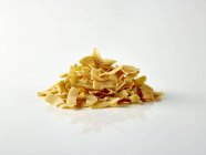 Closeup view of coconut crisps in a heap on a white surface — Stock Photo