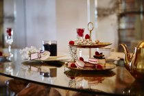 Macaroons and raspberries on cake stand — Stock Photo