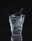 Salpicaduras de agua de un vaso - foto de stock