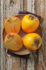 Whole and halved persimmons — Stock Photo