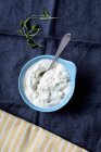 A blue  bowl with spoon of remoulade over towel — Stock Photo