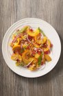 Kürbissalat mit Granatapfelkernen und Zitronenconfit auf weißem Teller — Stockfoto