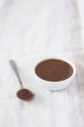 Closeup view of caramel sauce in bowl and on spoon — Stock Photo