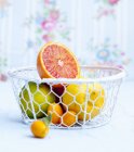 Citrus fruits in wire basket — Stock Photo