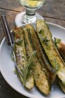 Zucchine марината - жареные кургетты с розмарином на белой тарелке с вилкой — стоковое фото
