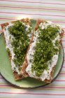 Pane croccante con quark ed erba cipollina su piatto verde sul tavolo — Foto stock