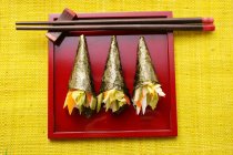 Temaki-Sushi auf rotem Teller — Stockfoto